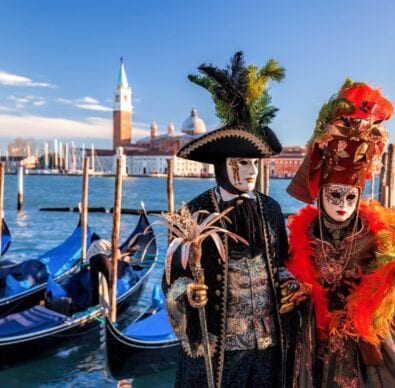 festival of Venice two masked goers near gondolas